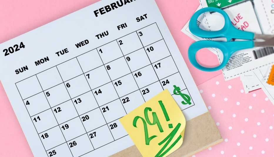 a calendar with a sticky note with the leap day written on it and a scissor with cut up coupons