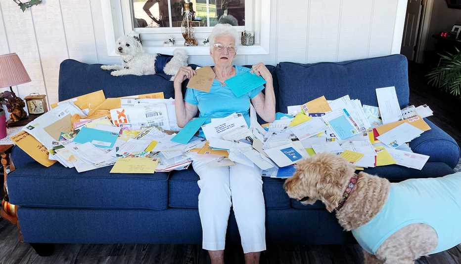 a woman on a couch surrounded by letters and a dog