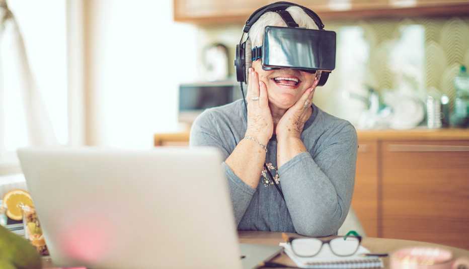 A woman wearing VR goggles at her kitchen table