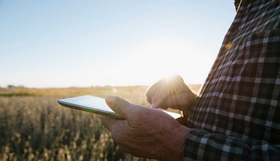 Man holding a tablet in a field