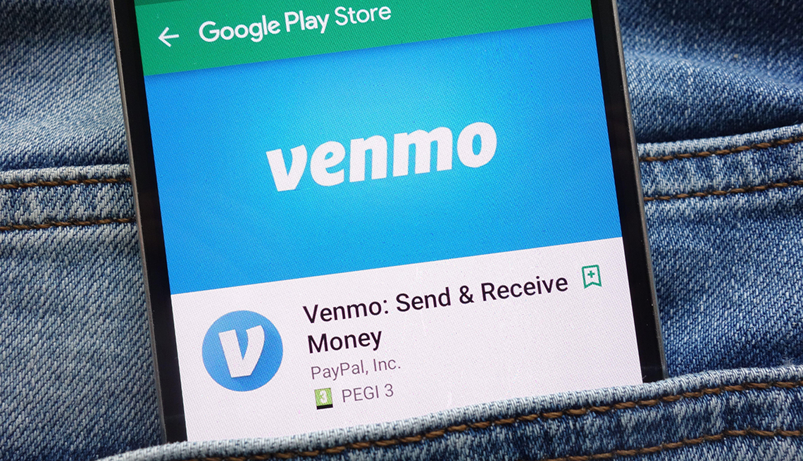 Venmo app on Google Play Store website displayed on smartphone hidden in jeans pocket