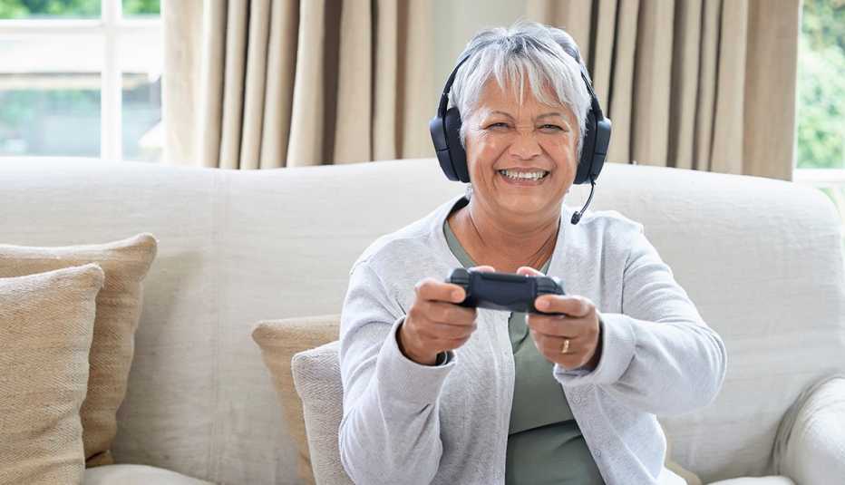 A woman playing video games in her living room with headset on