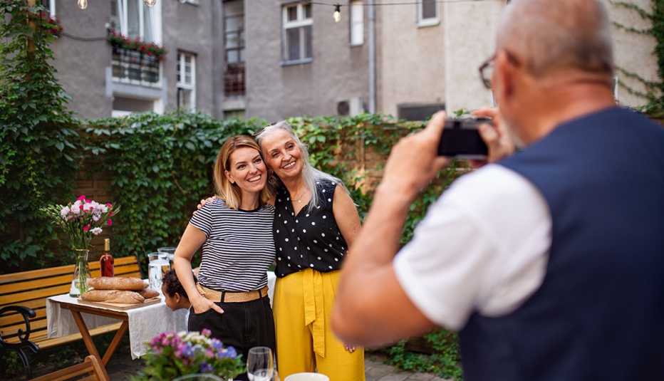 two women have their picture taken by a man