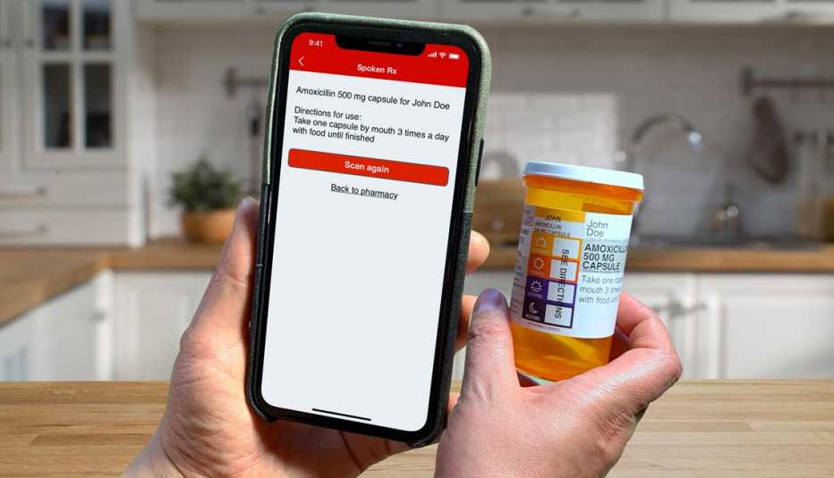 a hand holding a phone using the spoken r x app to scan a prescription label and instructions out loud