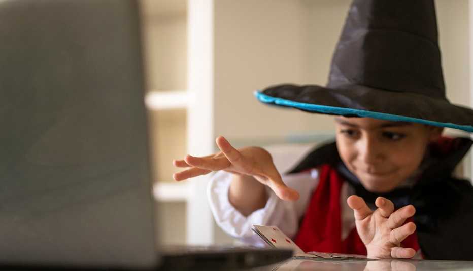 a child performing a magic trick in front of a computer