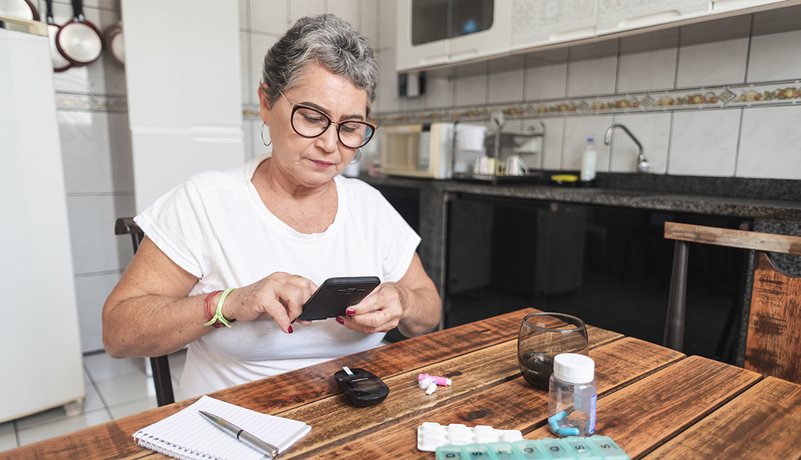 a woman looks at her phone while taking her medication