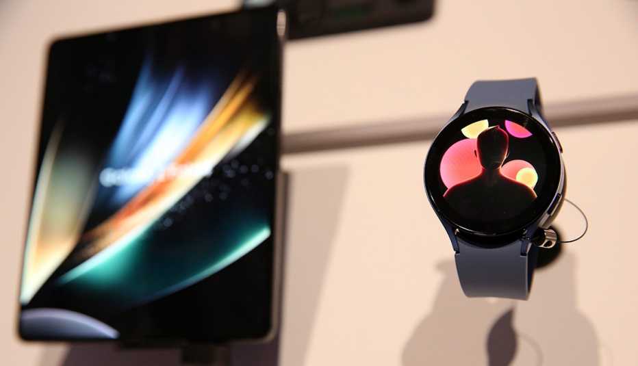 a samsung galaxy zfold4 mobile phone and a samsung galaxy watch5 on display on a white background