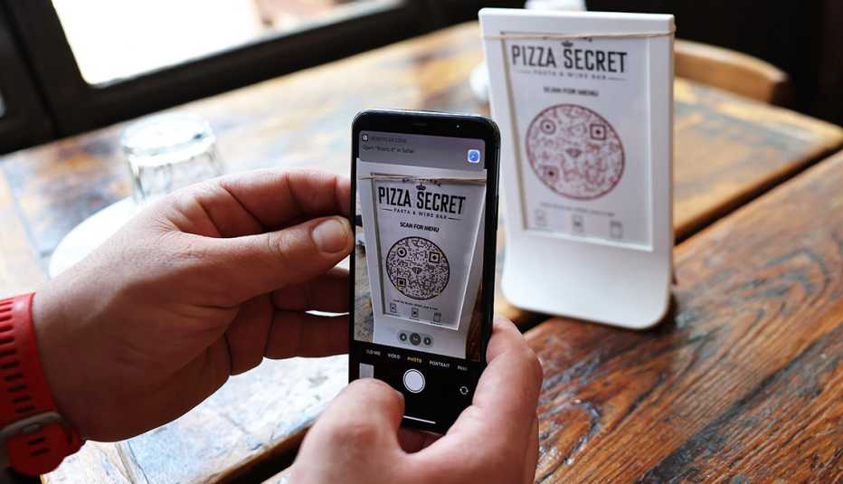 a person uses a smartphone to scan a menu