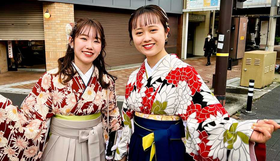 two japanese women gesture broadly in traditional outfits