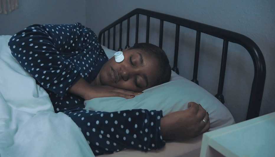 a woman wearing a baritone device to measure sleep apnea