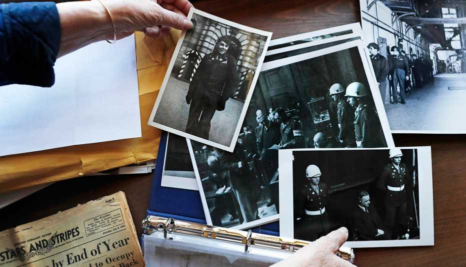 In this May 13, 2020 file photo, Emily DiPalma Aho looks over photographs and memorabilia of her father, Emilio DiPalma, a World War II veteran, 