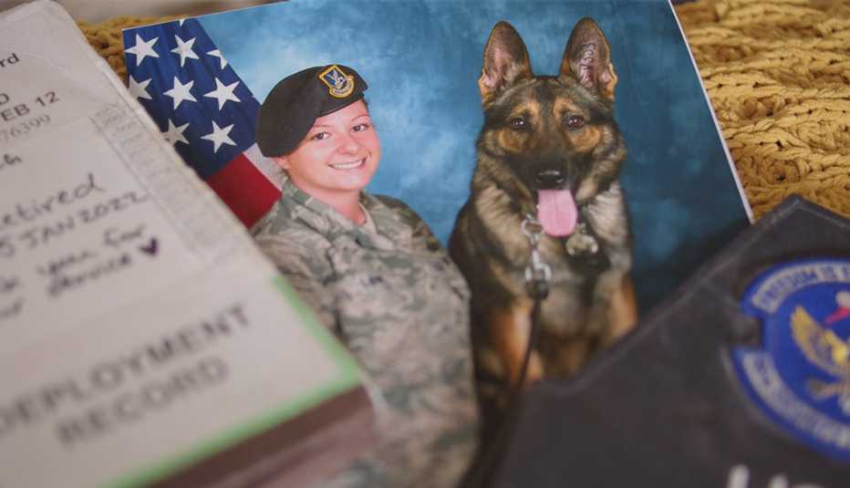 older photograph of staff sergeant angela lowe and her military canine named szultan along with his deployment record