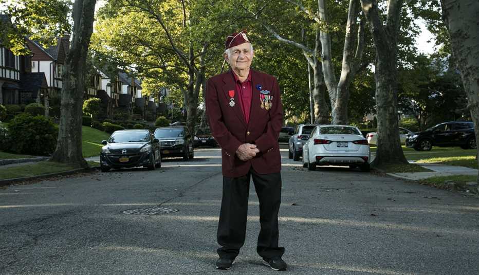 Harold Radish stands on his suburban street in a suit with military decoration