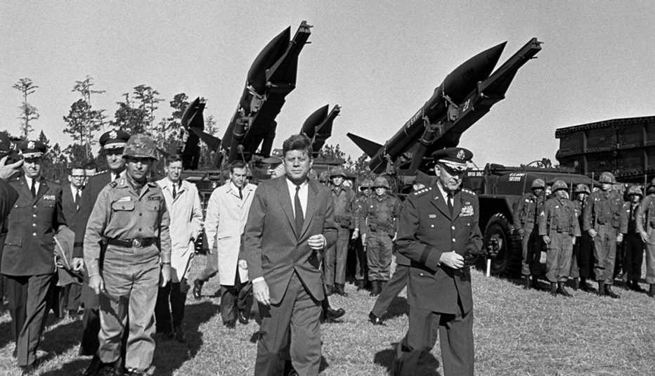 john f kennedy touring a military installation with members of the military