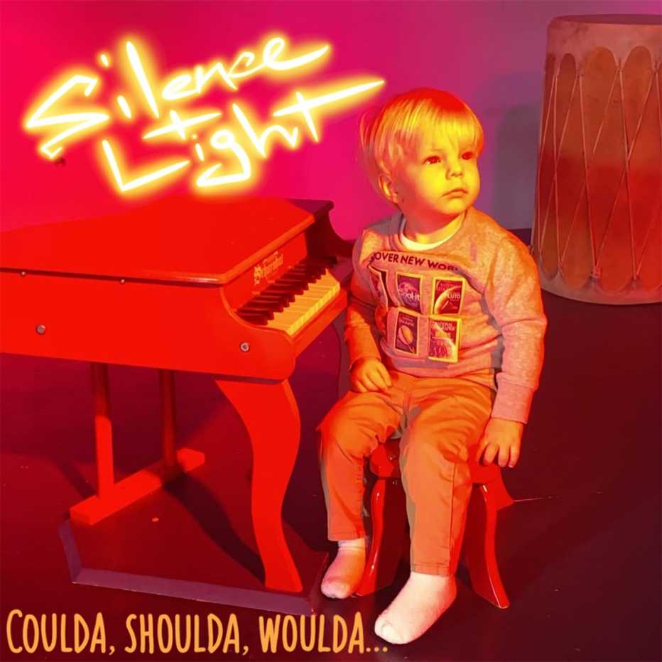 a young child sits at a piano in the album cover for the silence and light album coulda, shoulda, woulda