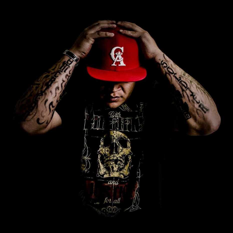 recording artist soldier hard poses with his head down wearing a black t shirt and red baseball hat