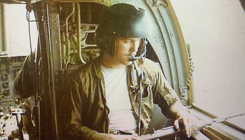 a man sitting in a helicopter during the vietnam war