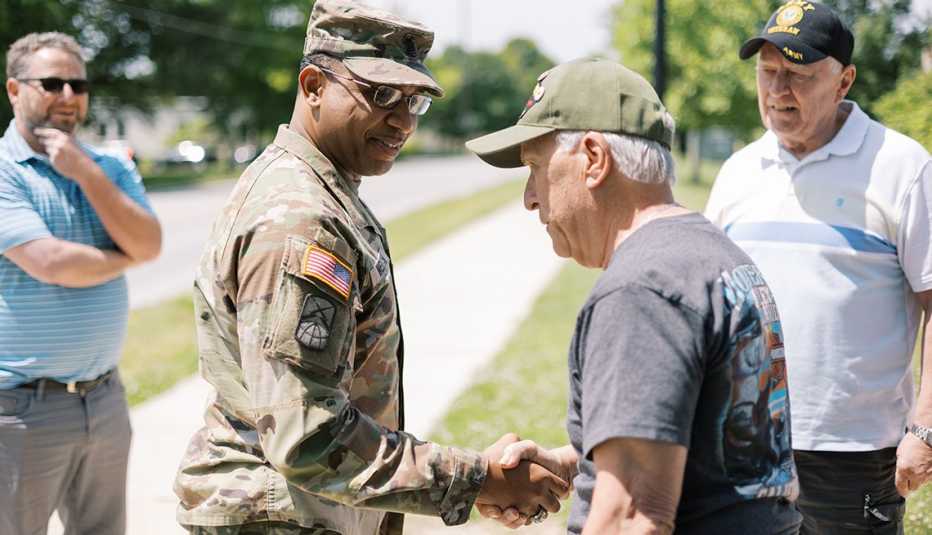 Thomas Fischer shakes hands with command sergeant major Andre Welch.