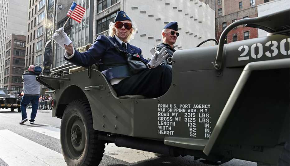 A veteran waves a small american flag during a parade