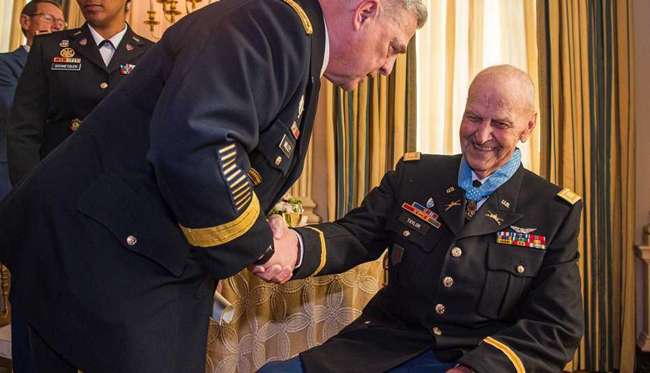 Two men in military uniforms shake hands