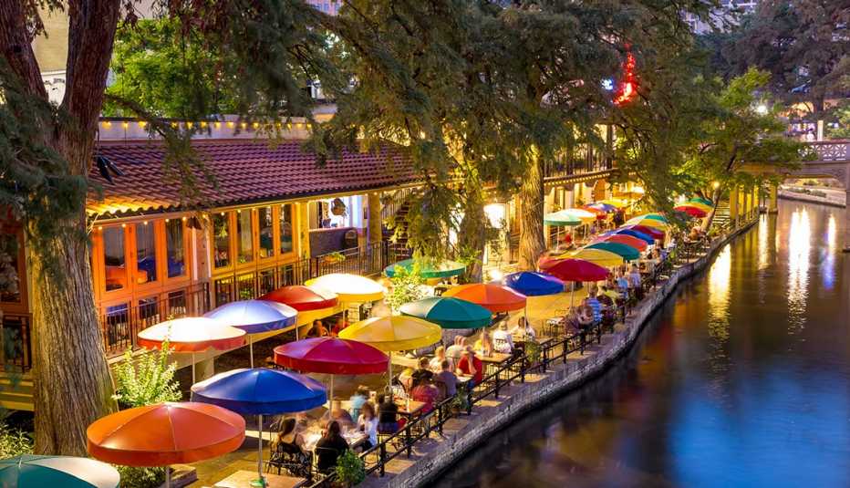 colorful table umbrellas line the river walk in san antonio, texas