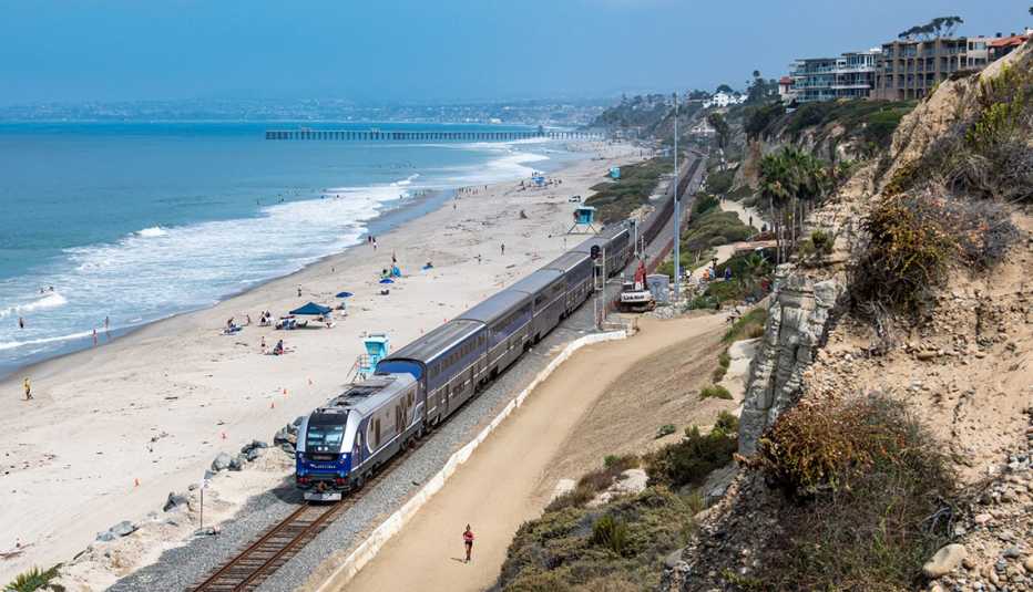 an amtrak train runs alongside a beach