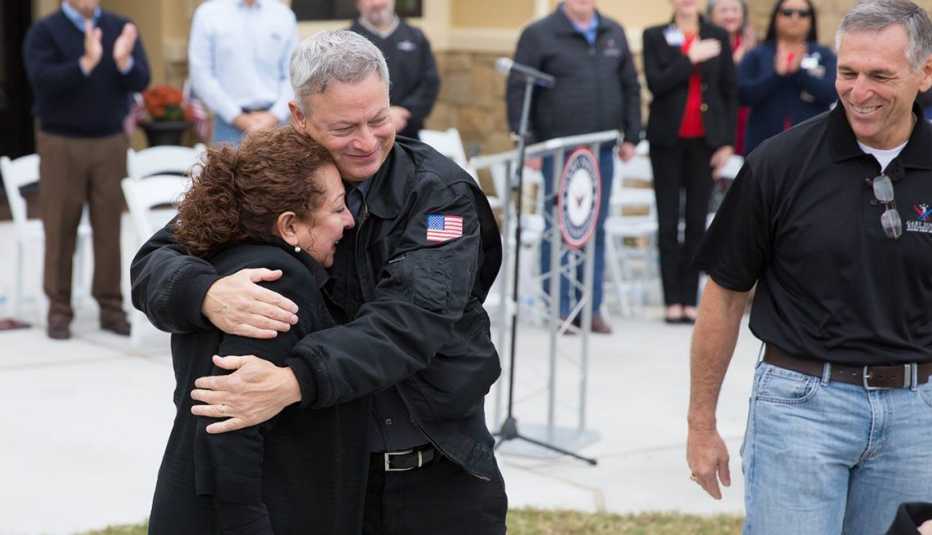 Gary Sinise hugs Rosie Babin as the crowd celebrates her family's new home in 2017