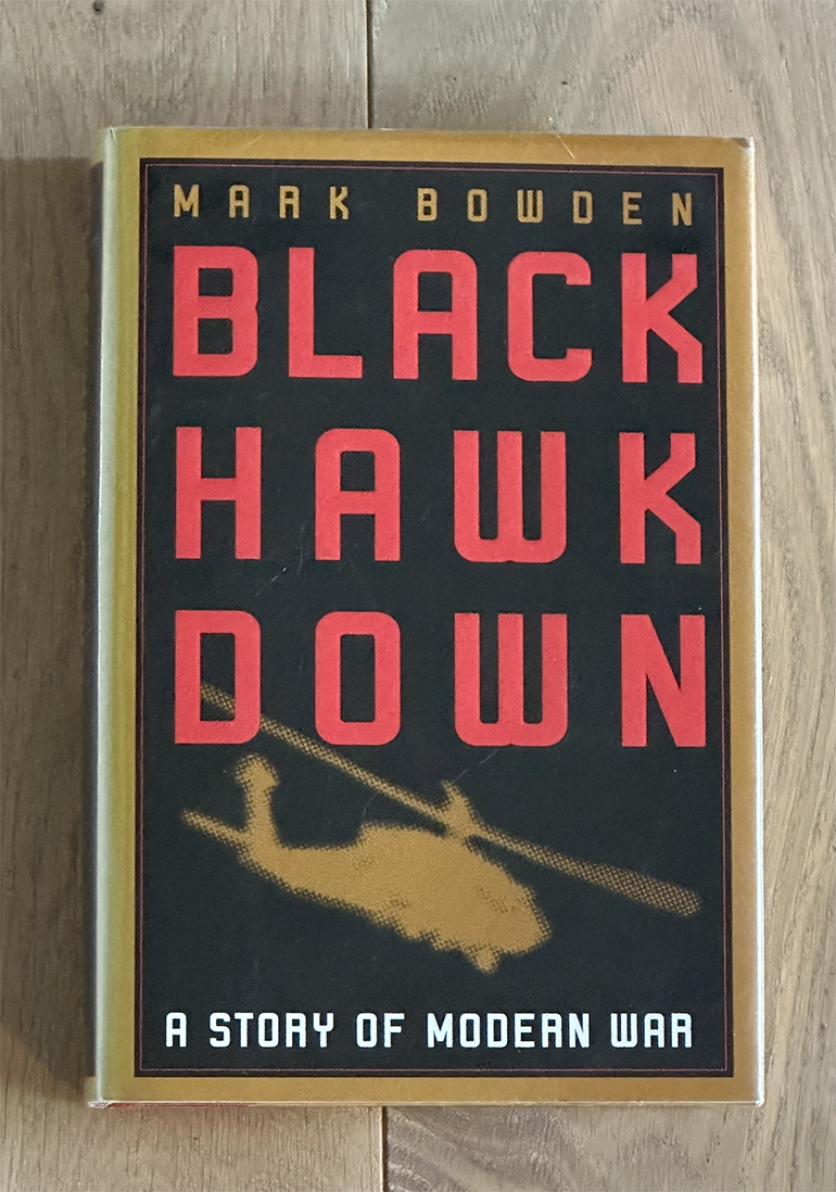 mark bowden's book black hawk down sits on a wood table