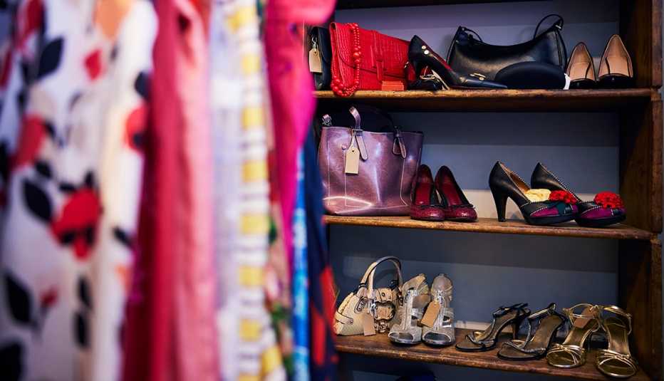 women's clothing on a rack in front of shoes and bags on thrift shop shelves