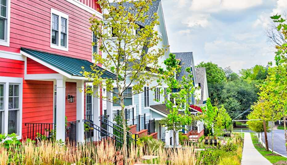 Colorful multicolored red, blue painted residential new townhouses, homes, houses in Maryland with cars on street.