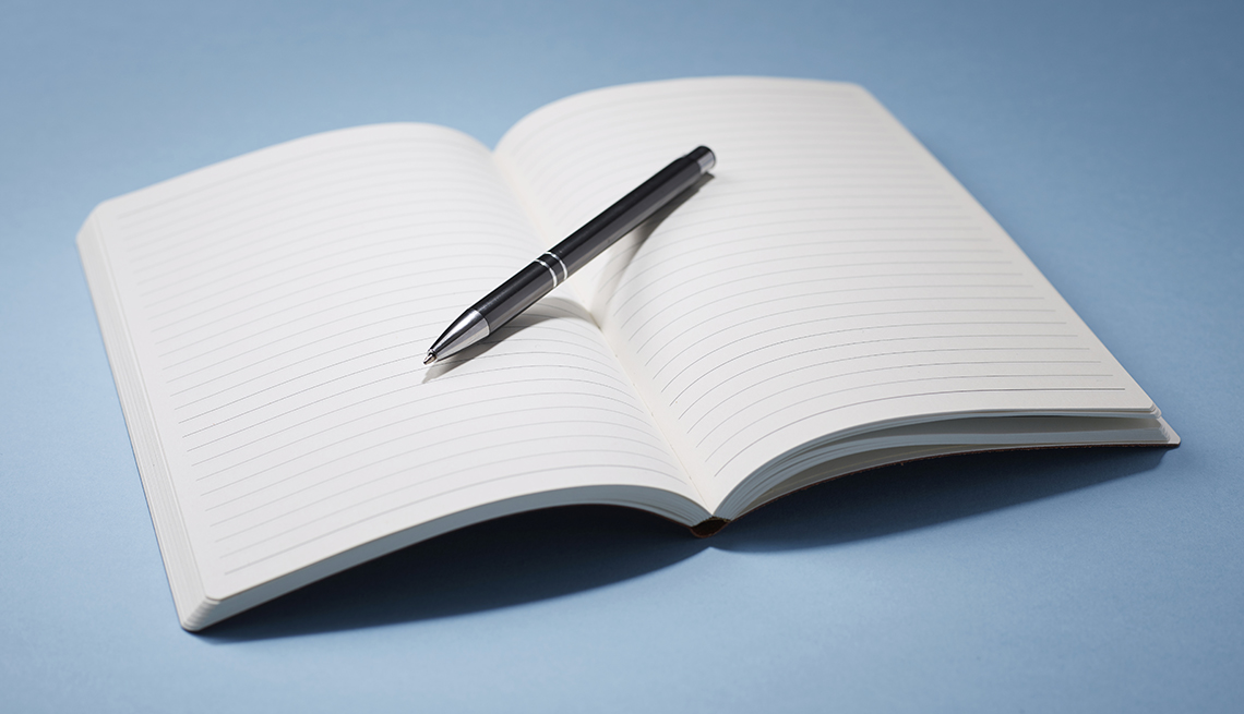 an open notebook with a pen on top on a blue background
