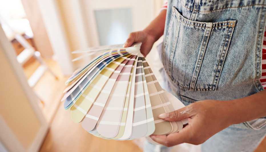 A woman choosing paint color from swatch at home