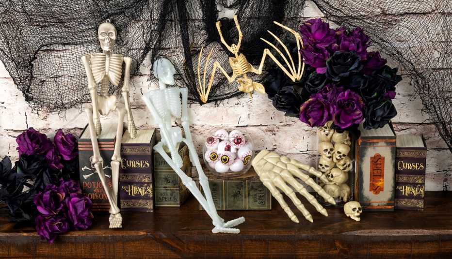 a mantle decorated for halloween with skeletons and eyes and flowers
