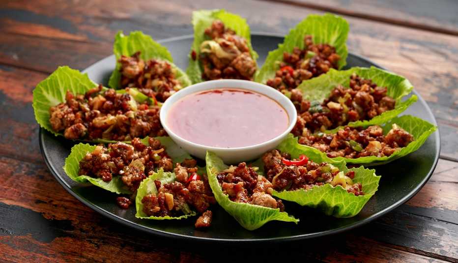 Chilli Beef Lettuce Wraps with sauce on black plate.