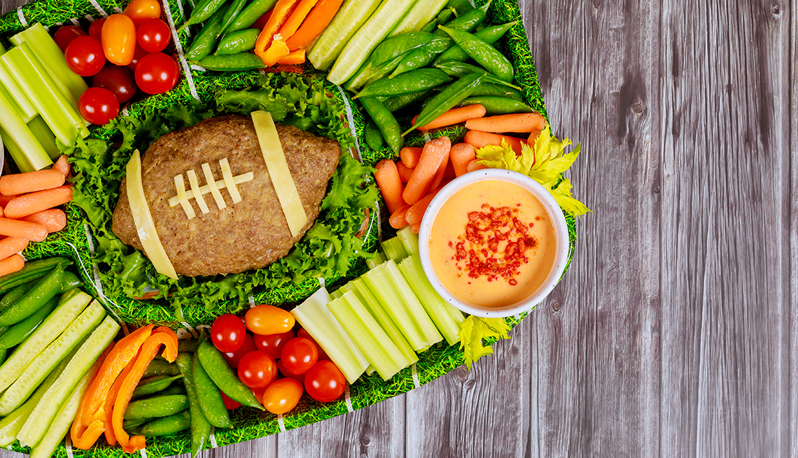 Football meatloaf with fresh vegetable platter and dipping for championship game fan party.