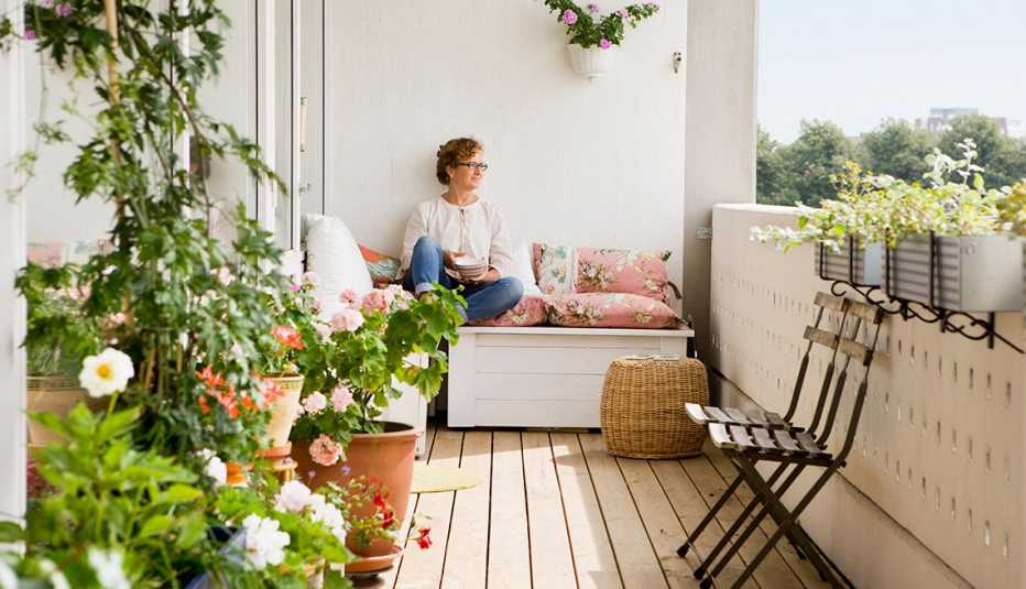 Woman sits smiling on her balcony