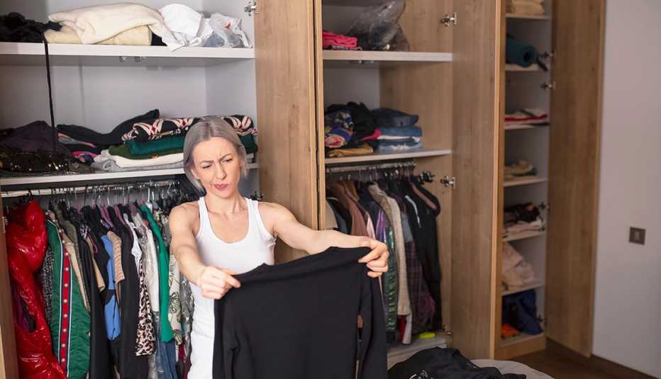 woman sitting on the floor, decluttering her closet