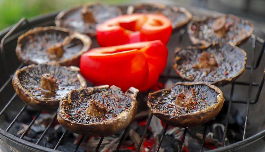 portabella mushrooms on a grill with red peppers 