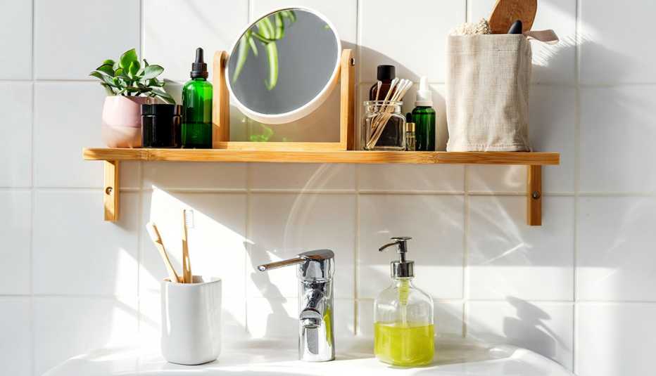 Toothbrushes soap a mirror and other toiletry items located above a bathroom sink
