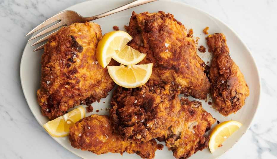a plate of fried chicken with lemon slices