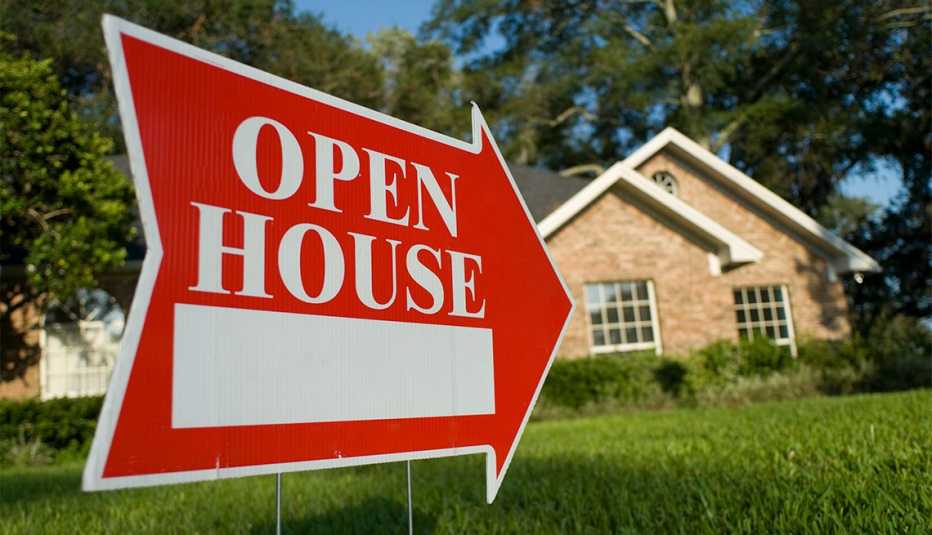 a sign that says open house in front of a home