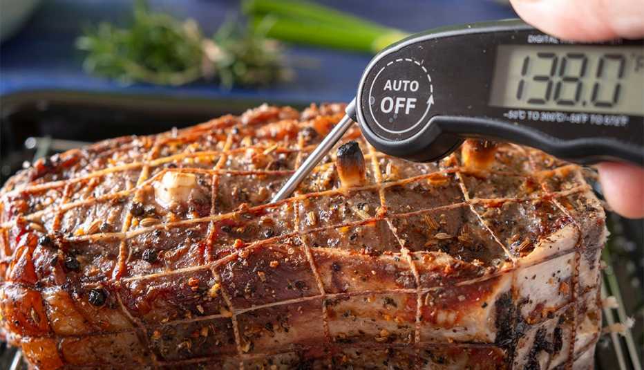 Checking roasted beef with digital thermometer
