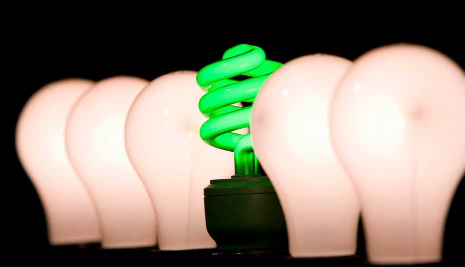 incandescent light bulbs surrounding a green LED lightbulb