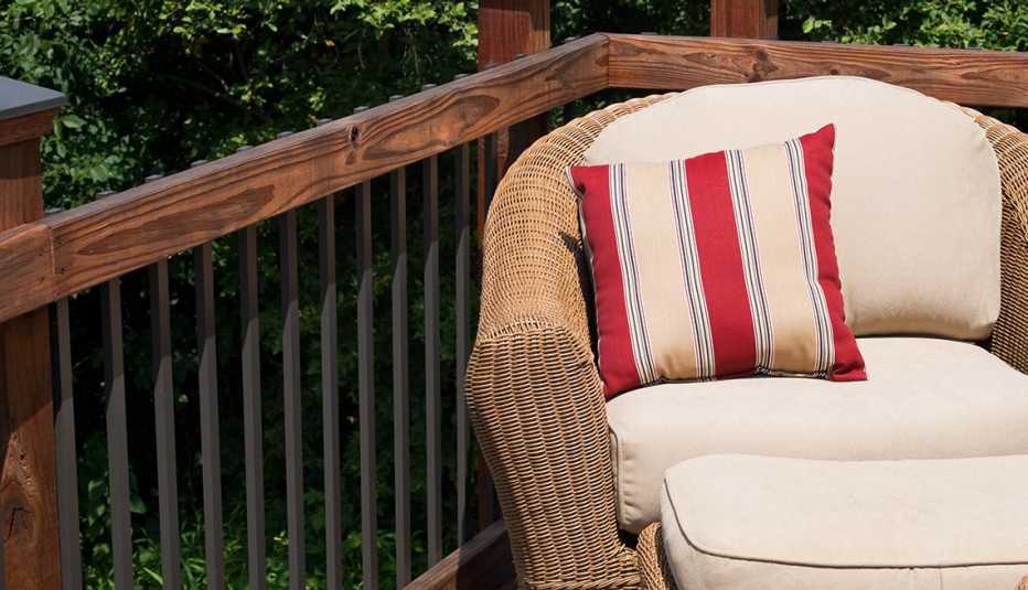striped throw pillow and cushions on an outdoor wicker chair