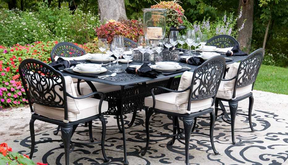 wrought iron patio table set for fine dining with cloth napkins and stemmed wine glassware