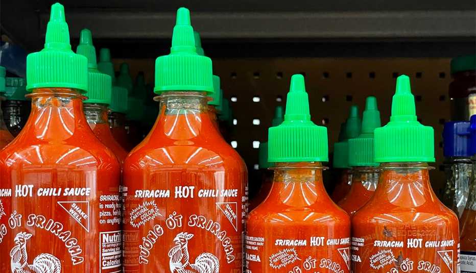 Bottles of Huy Fong Foods Sriracha sauce are displayed on a supermarket shelf 