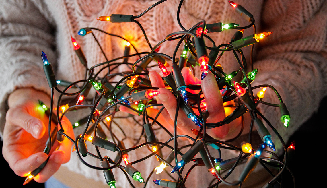 Holding a tangled string of Christmas lights