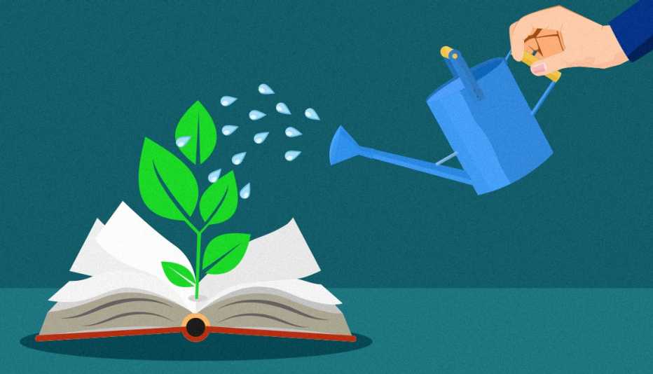 hand holding a watering can watering an open book with a green plant growing out of the pages