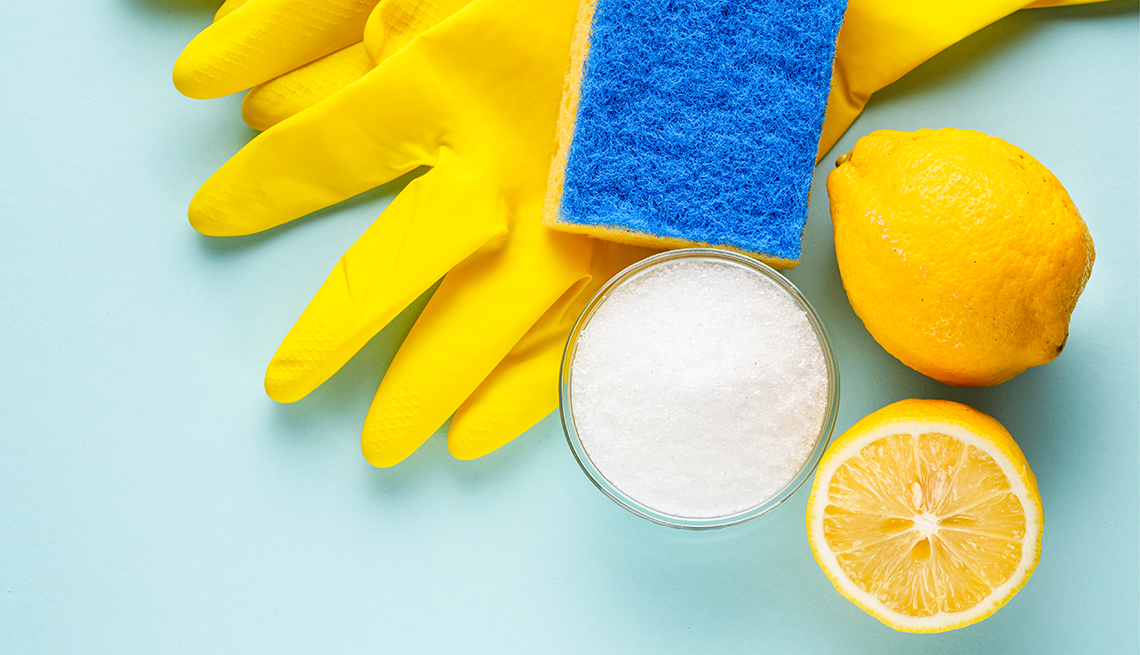 Cleaning supplies - sponge, lemon, salt, and rubber gloves
