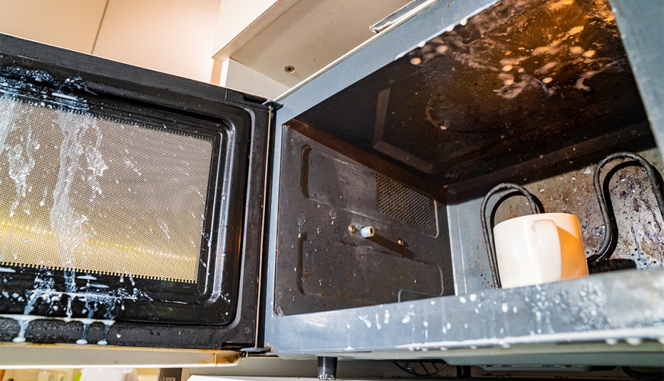 a messy microwave where a cup of milk exploded while being heated